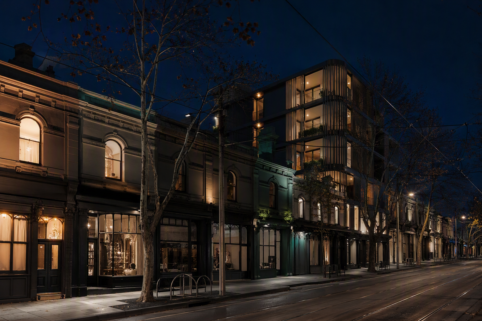 Early evening view of an inner-Melbourne street near Acland Street, with Victorian shopfronts, above-shop apartments and a contemporary apartment building alongside.