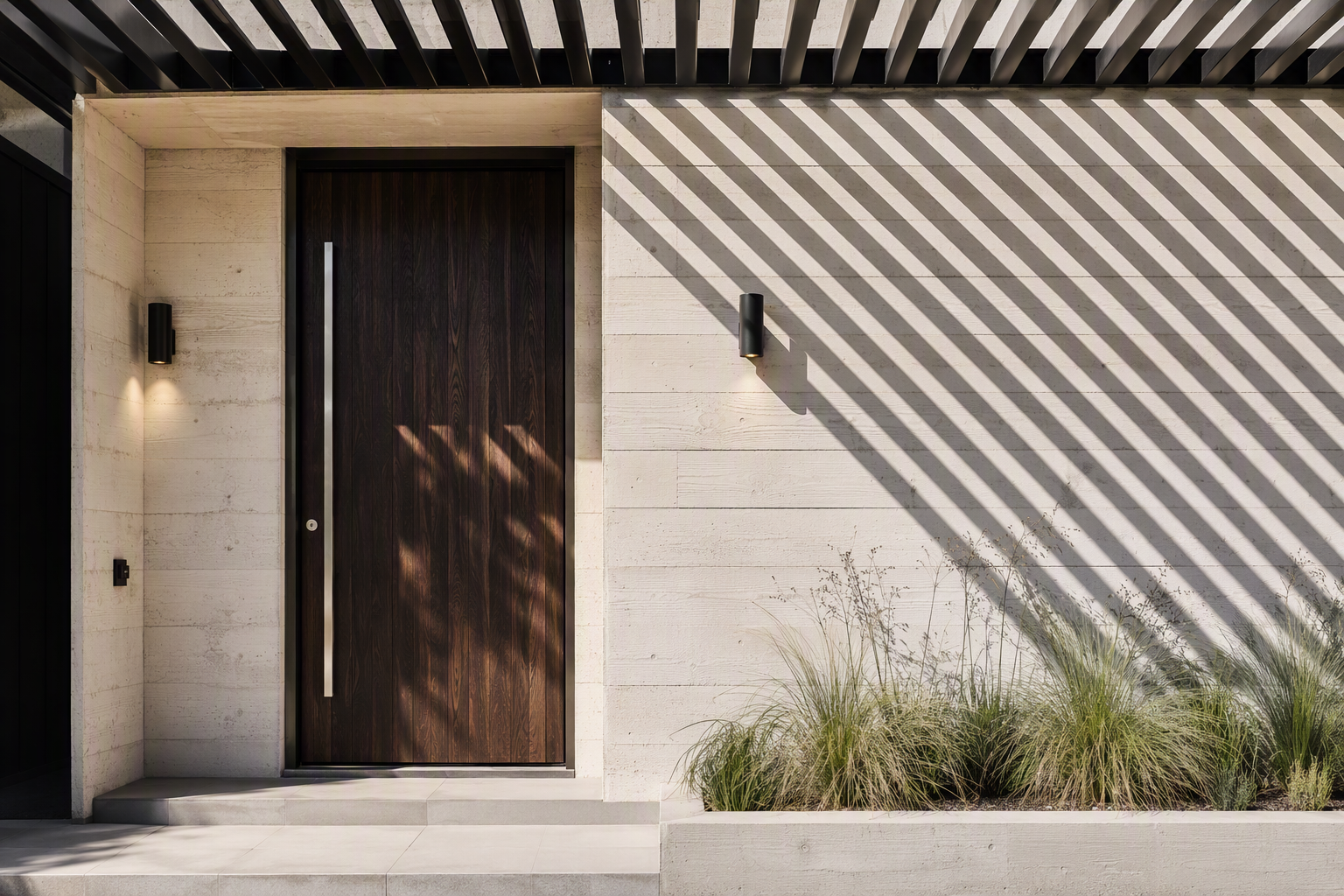 Wide dark timber pivot entry door with a full-height stainless pull in a board-formed concrete apartment development