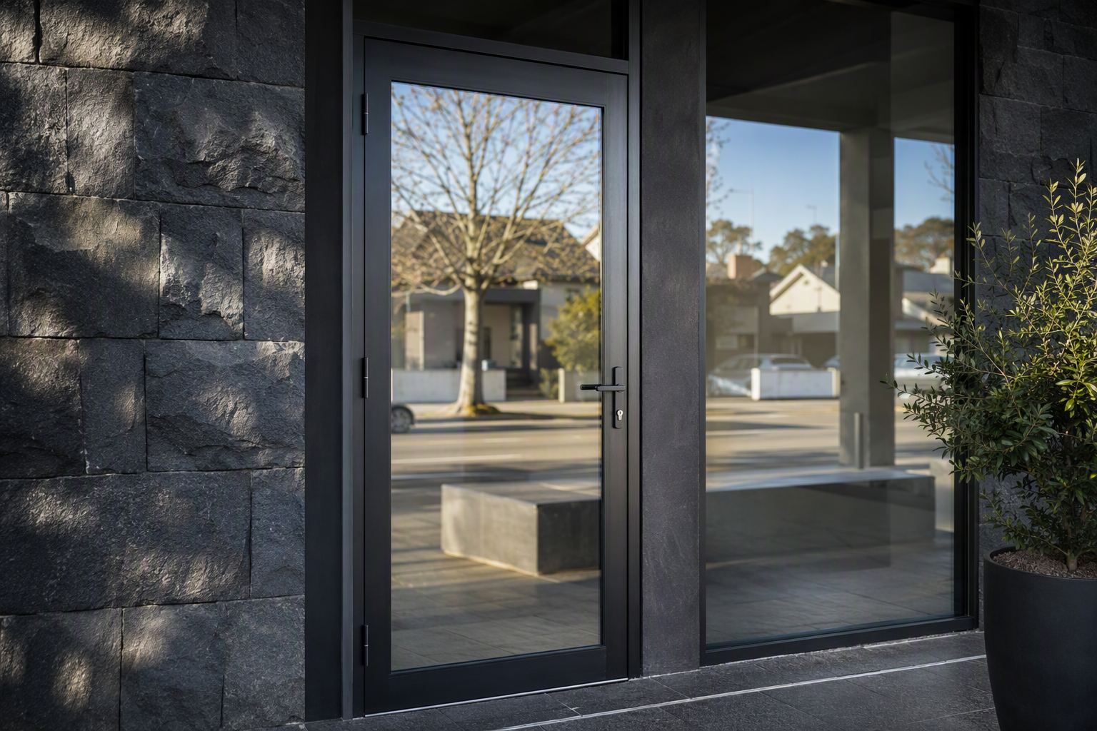 Modern Melbourne shopfront with a slim black-framed glass entry door and commercial lever handle