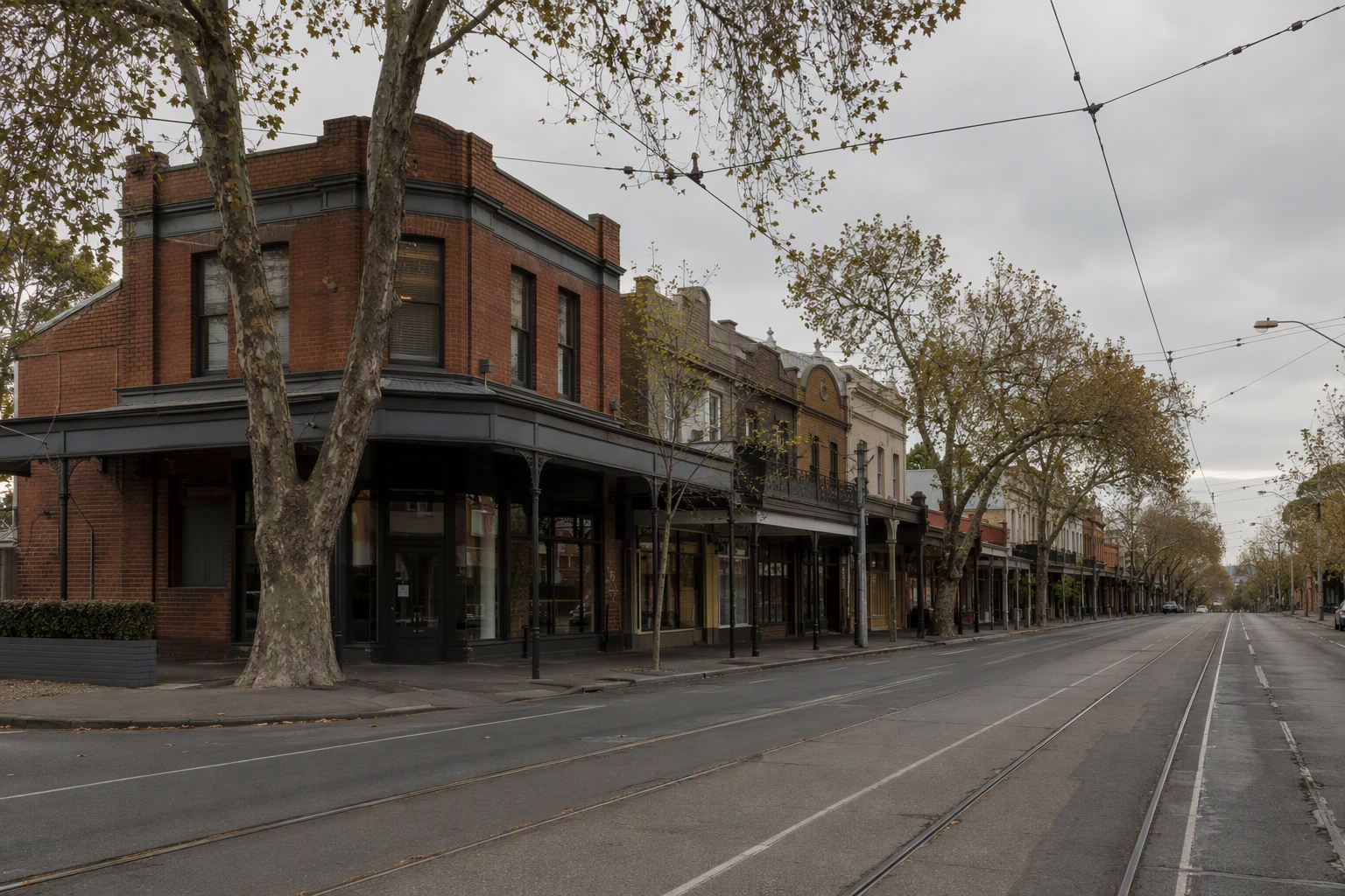 Quiet suburban Melbourne shopping strip with verandahs, tram tracks and overhead wires