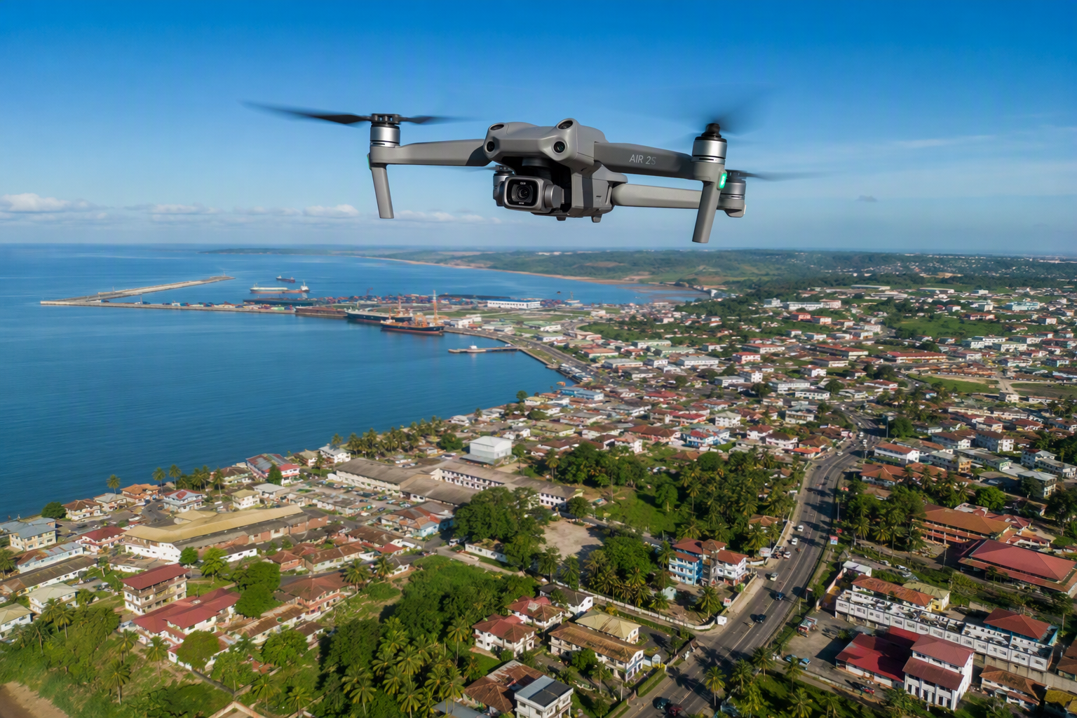 Drone quadricoptère en vol au-dessus d'une ville côtière