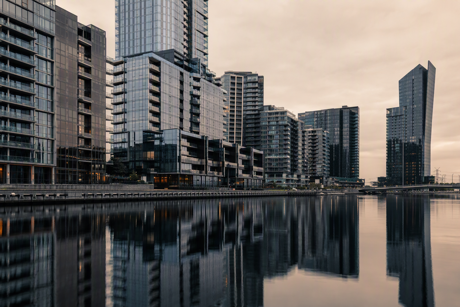 Docklands waterfront towers with glass and metal facades reflected in still harbour water