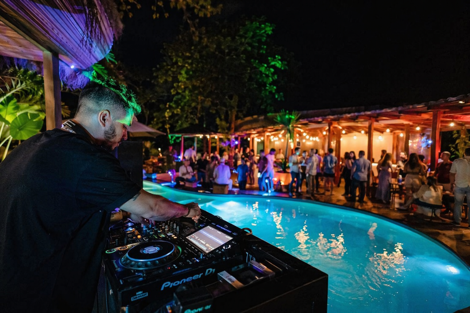 DJ performing at a pool party at night